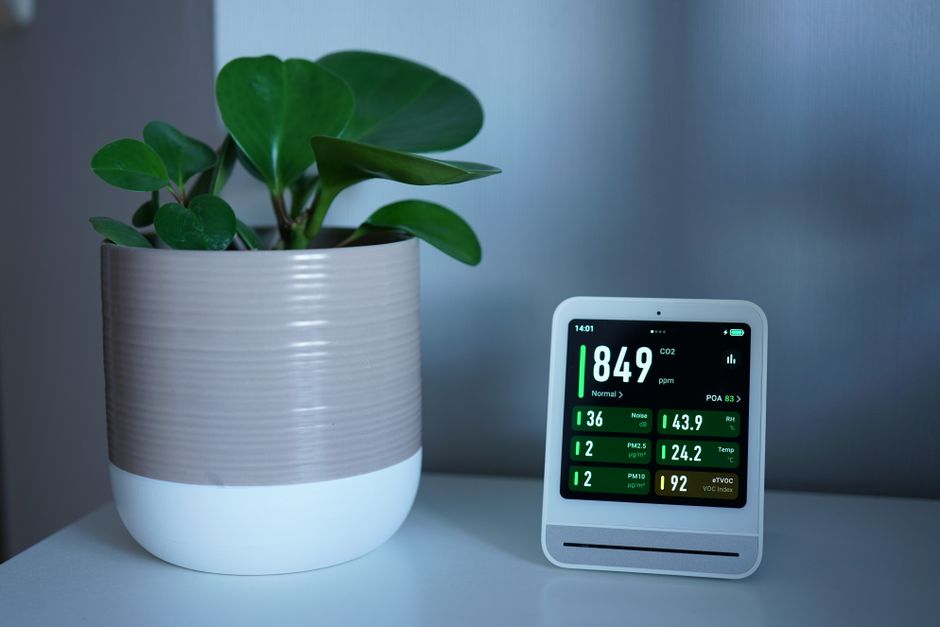 Basement Dehumidification in Fort Lee, NJ — Air quality monitor next to a potted plant on a desk, showing CO2 and PM2.5 levels.