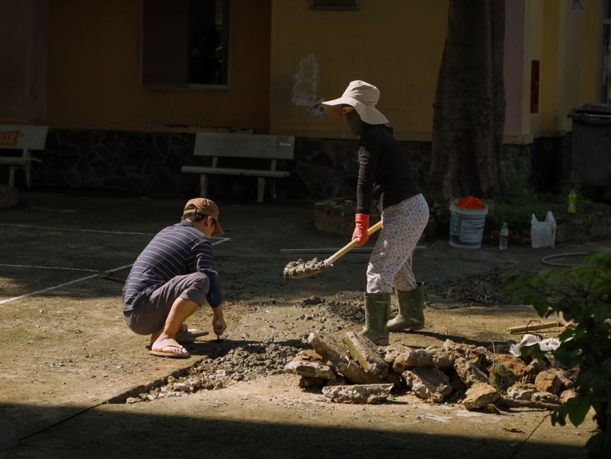 Foundation Crack Repair in Fort Lee, NJ — Two people engaged in concrete work outdoors in Hồ Chí Minh City, Vietnam.